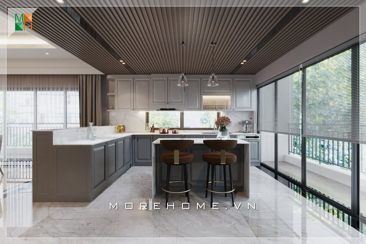 Mẫu thiết kế phòng bếp cho nhà phố, biệt thự, với hệ thống tủ bếp gỗ khắc những chi tiết ô vuông truyền thống, bàn đảo bếp mặt đá nhân tạo hiện đại, ghế bar bọc nỉ cao cấp đến đèn thả trần duyên dáng, tạo nên vẻ đẹp vừa hiện đại sang trọng mà vẫn có nét gì đó cổ điển Thiết kế phòng bếp biệt thự